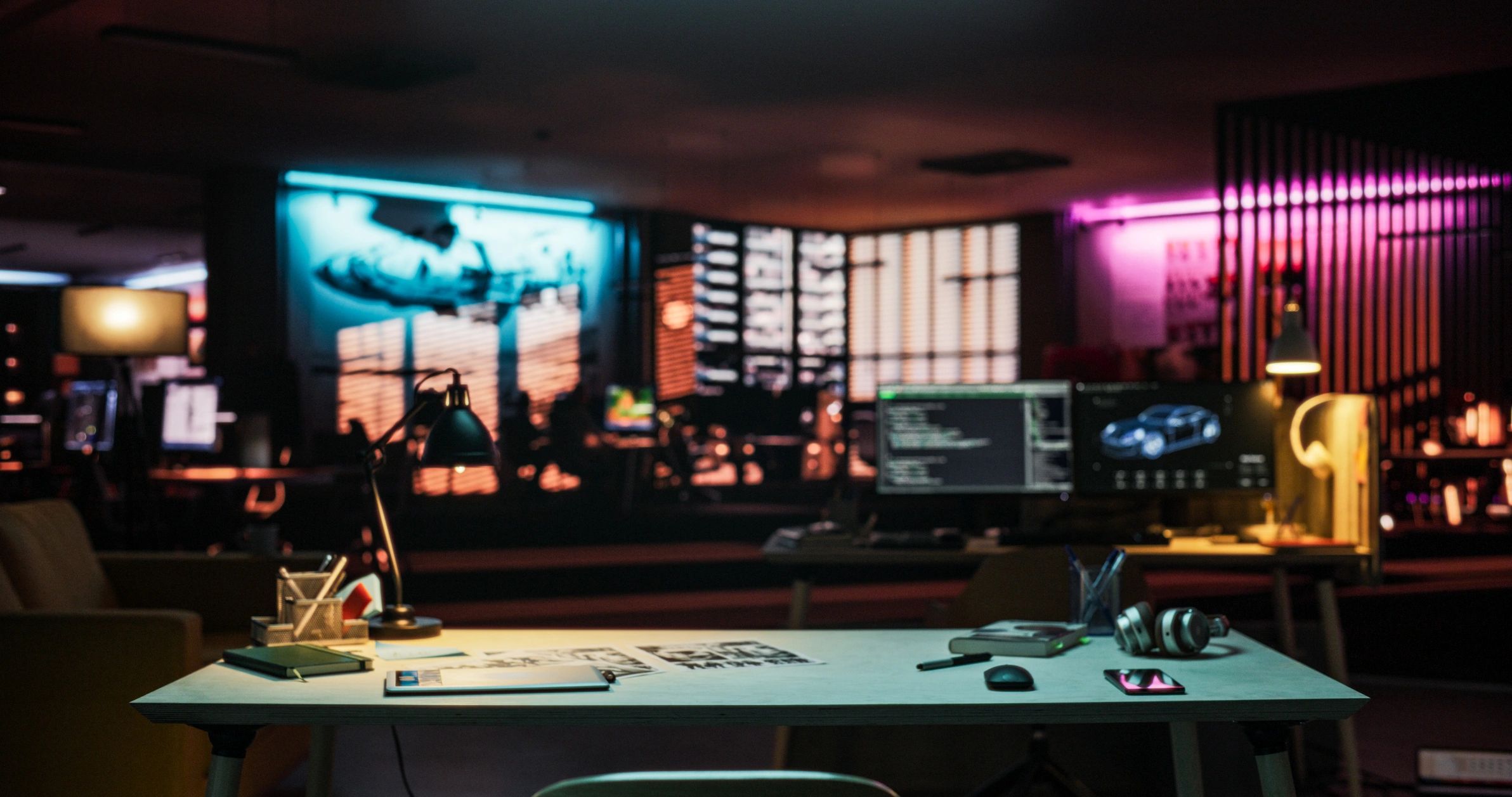 Neon-lit creative office desk setup at night
